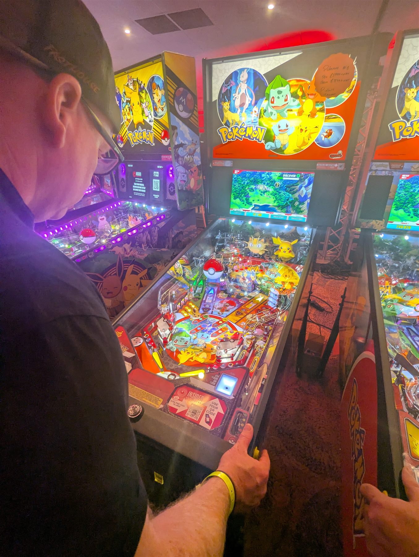 Player trying a Pokémon pinball machine at UK Pinfest