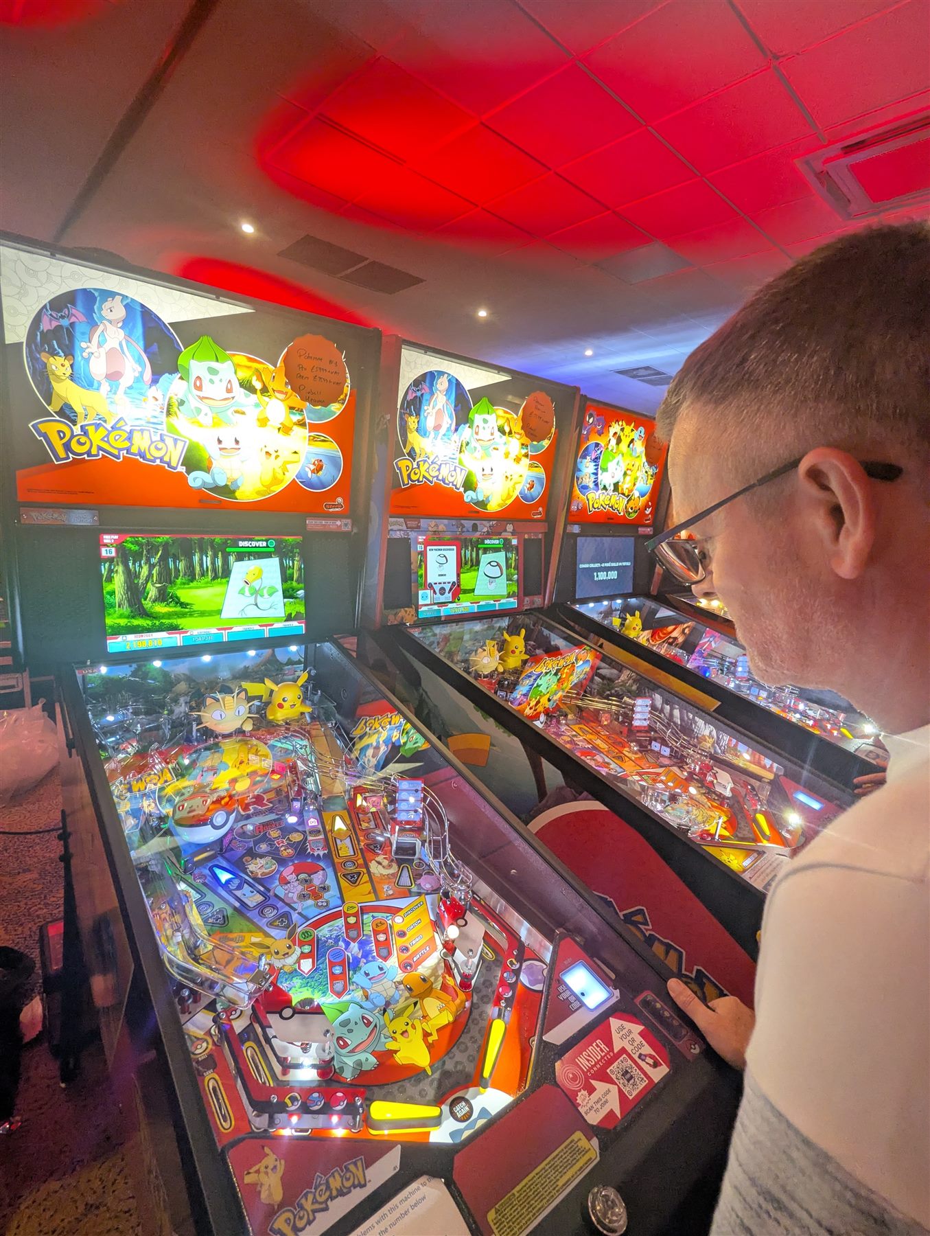 A row of Pokémon pinball machines being played at UK Pinfest